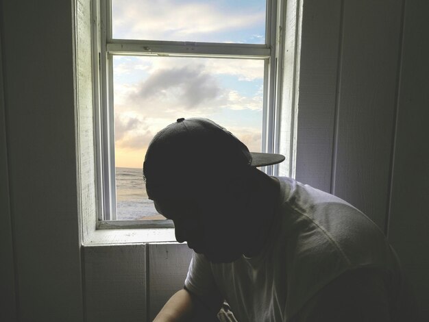 사진 집의 창문 에 앉아 있는 남자