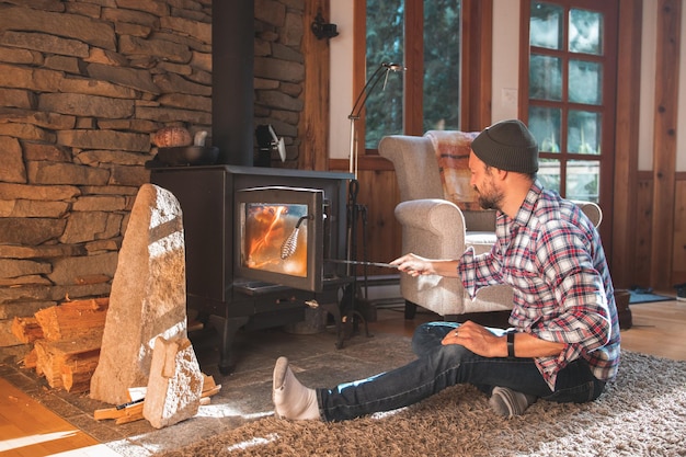 Photo man sitting on carpet by fireplace at home