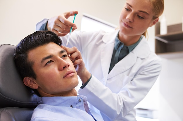 Man Sitting In Chair Being Give Botox Injection By Female Doctor