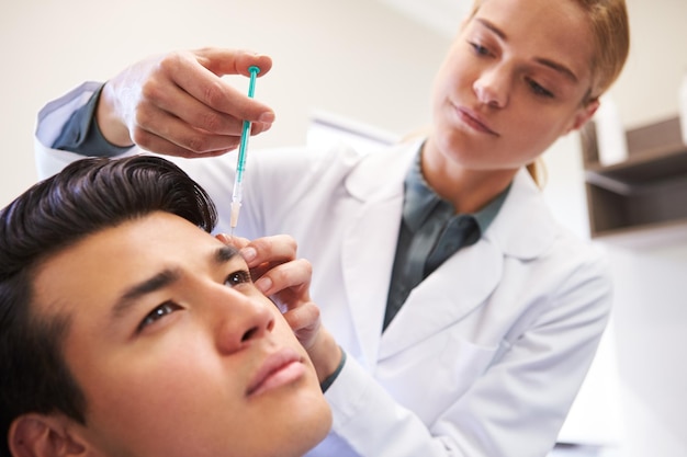 Man Sitting In Chair Being Give Botox Injection By Female Doctor