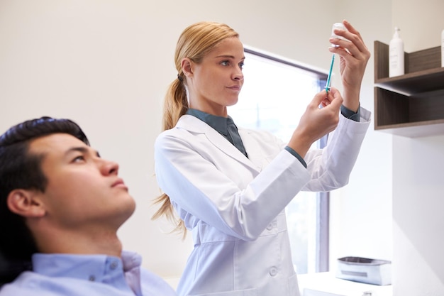 Man Sitting In Chair Being Give Botox Injection By Female Doctor