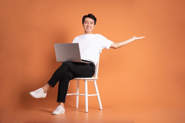 Man sitting on chair isolated on orange background