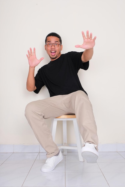 A man sitting on the chair showing wow face expression