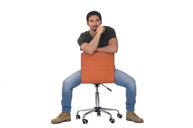 Photo man sitting on a chair that is turned and hand on face on white background