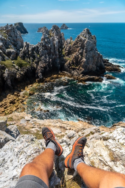 Photo a man sitting on the cliffs at pen hir point on the crozon peninsula in french brittany