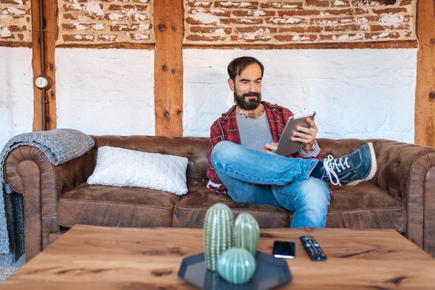 Man sitting in the couch relaxed at home on the tabled