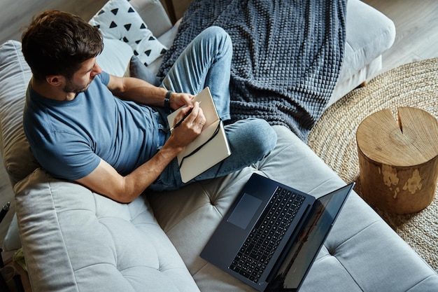 Man sitting on couch and using laptop