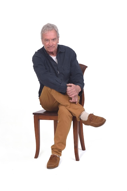 Man sitting on de chair looking at camera on white background