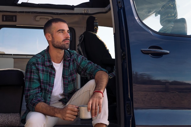 Man sitting in the door of his camper van