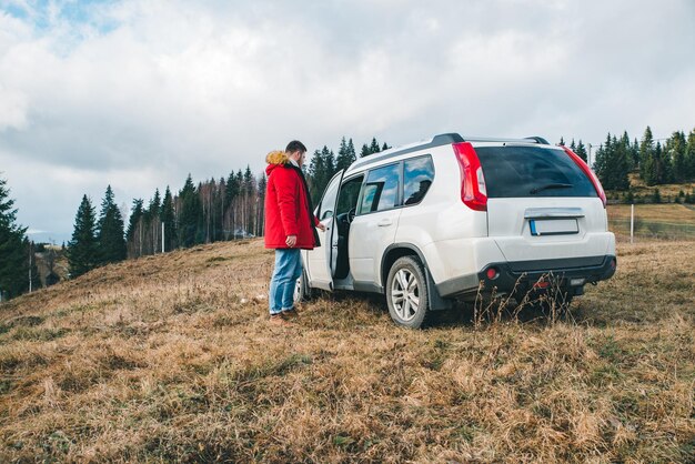 Man sitting down into white suv car off road trip car travel