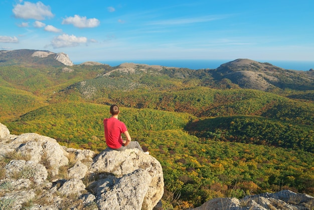 Man sitting on the edge of mountain