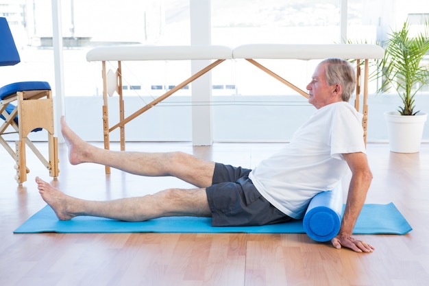 Man sitting on exercise mat 