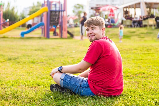 Photo man sitting on the grass