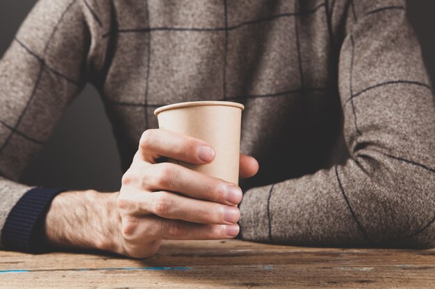 A man sitting holding a paper cup