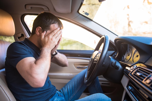 Man sitting inside the car is very sad and stressed