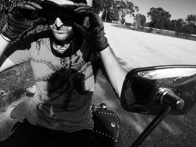 Photo man sitting on motorcycle at field