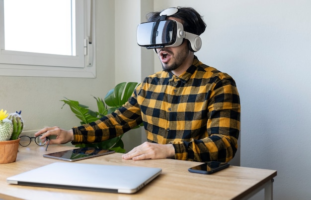 Человек сидит в офисе с очками виртуальной реальности
