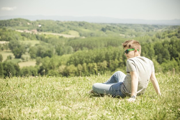 写真 芝生の畑に座っている男