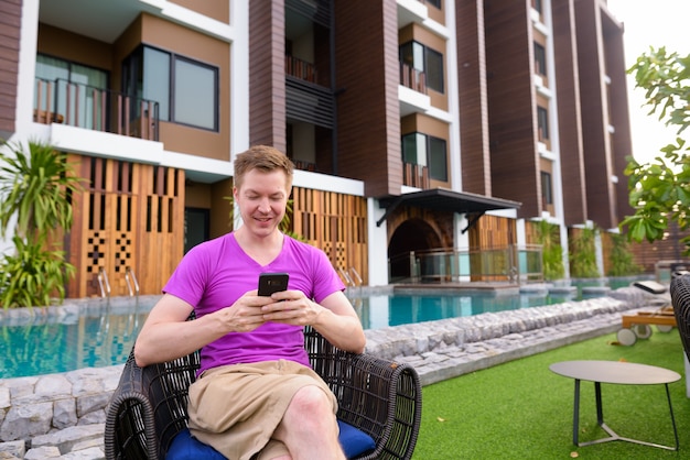 Man sitting outdoors and using mobile phone