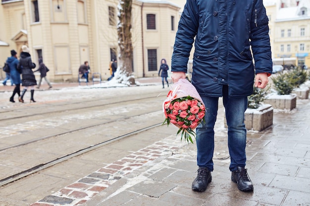 バラの花束を持って外の階段に座っている男性