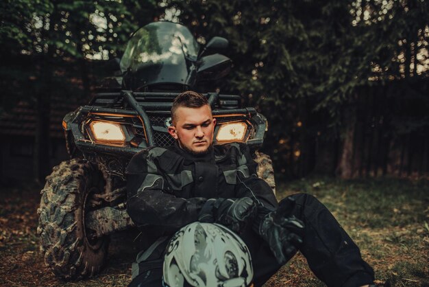 Man sitting and preparing equipment for extreme quad ride