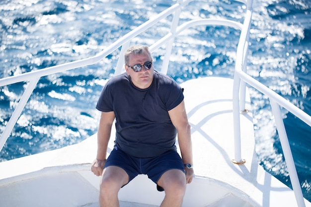 Man sitting on the prow of a boat