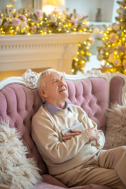 man sitting on a sofa looking at photo