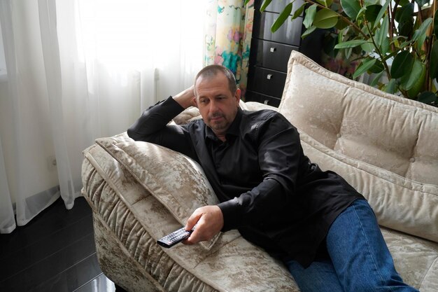 Photo man sitting on sofa and watching tv