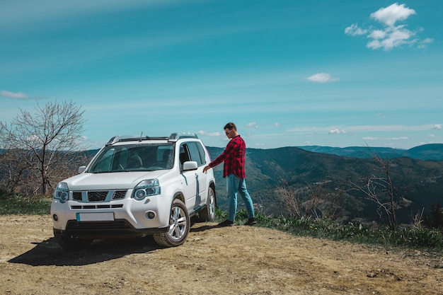 산 정상에서 suv 차에 앉아있는 남자