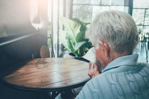 Man sitting on table by window at home