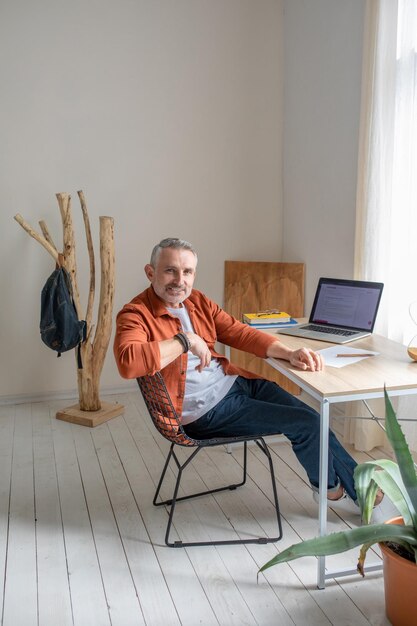 A man sitting at the table in the offcie and looking contented