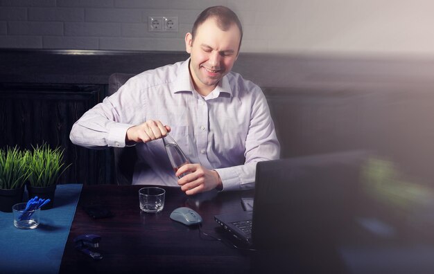 Человек сидит за столом и работает на ноутбуке