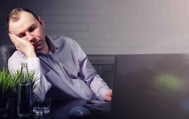 Foto uomo seduto al tavolo e lavorando sul laptop