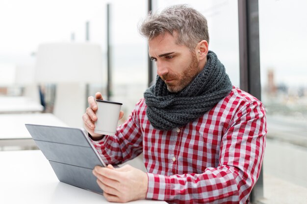 man sitting on a terrace in front of a tablet