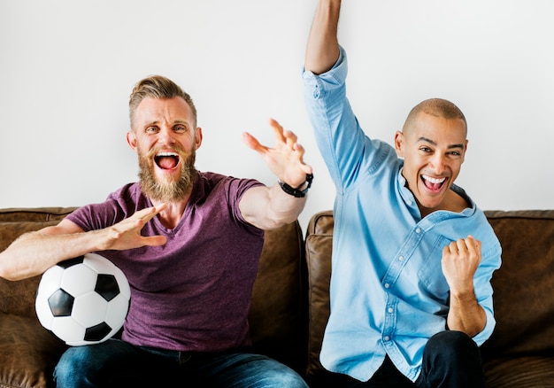 Man sitting together on a couch watching sport