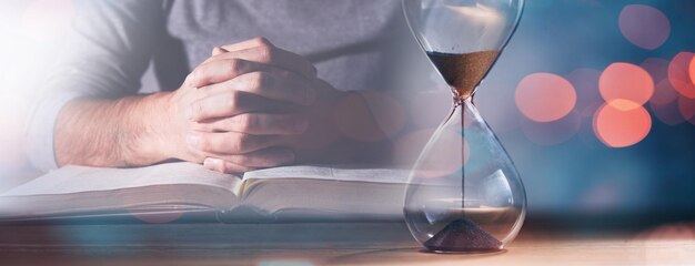 Man sitting with hands clasped in prayer and time