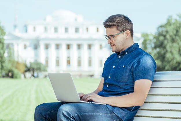 Man sitting with laptop outside the office