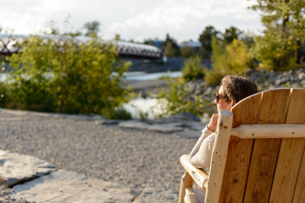 Man sitting on wood against trees