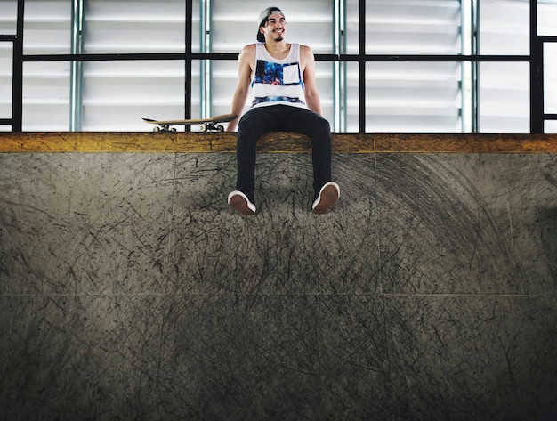 Foto lo stile di vita del skateboarder dell'uomo si rilassa il concetto dei pantaloni a vita bassa