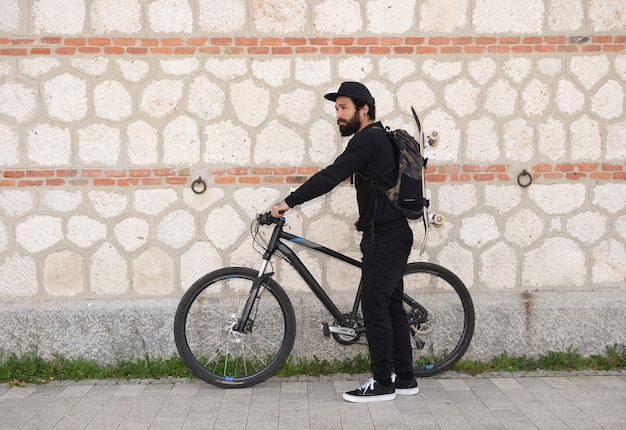 自転車のライフスタイルヒップスターのコンセプトを持つ男のスケートボーダー