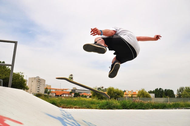 Foto uomo che fa skateboard nel parco degli skateboard