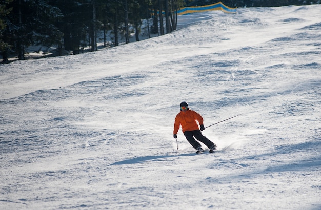 Man skier skiing downhill at ski resort