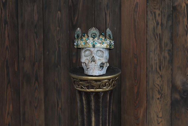 man skull with crown on stand