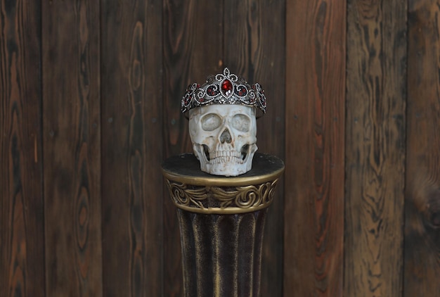 man skull with crown on stand