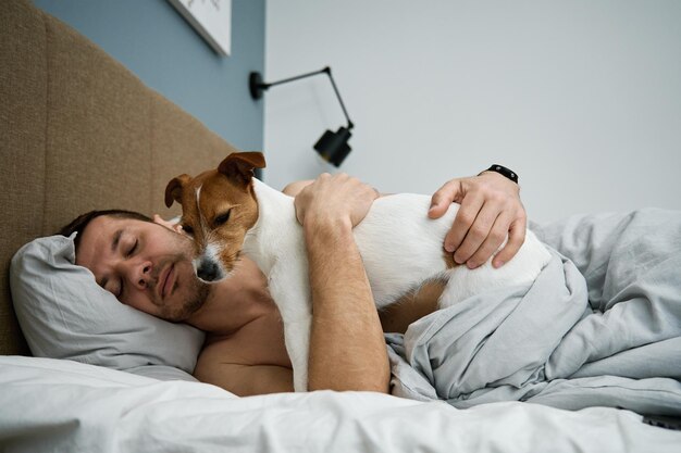 Man slaapt op bed met hond Pet genegenheid