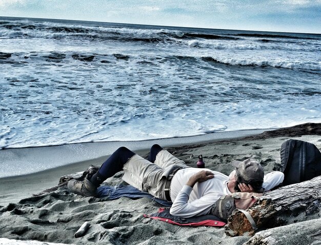 Man slaapt op het strand bij de zee