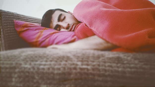 Photo man sleeping on bed in bedroom at home