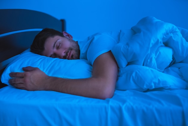 The man sleeping on the bed. evening night time