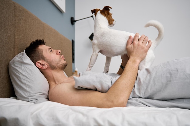 Man sleeping on bed with dog Pet affection