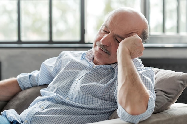 Man sleeping on couch taking afternoon nap at the living room